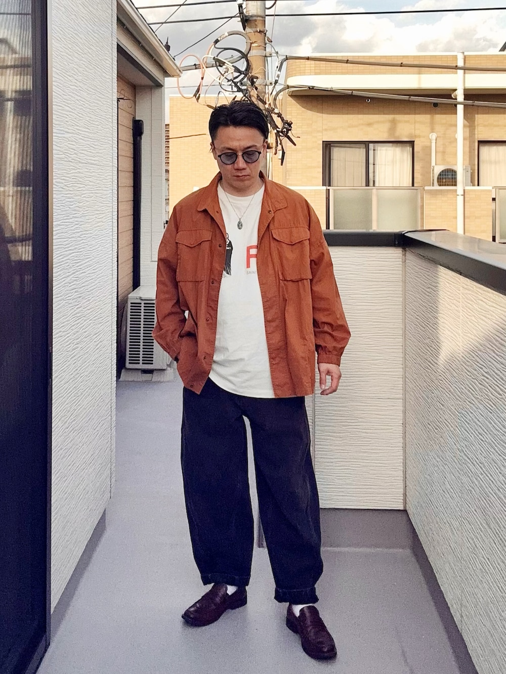 ブラック系のデニムパンツ、ホワイト系のTシャツ/カットソー、ブラウン系のシャツ/ブラウスを着用したメンズの春コーディネートの2枚目の写真