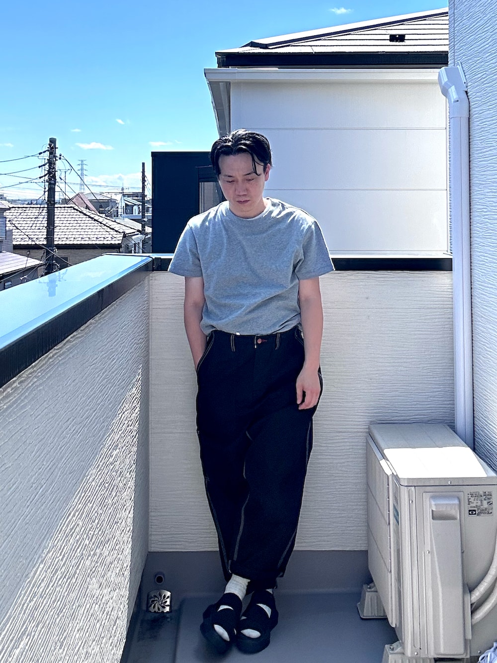 グレー系のTシャツ/カットソー、ブラック系のデニムパンツ、ブラック系のサンダルを着用したメンズの夏コーディネートの2枚目の写真
