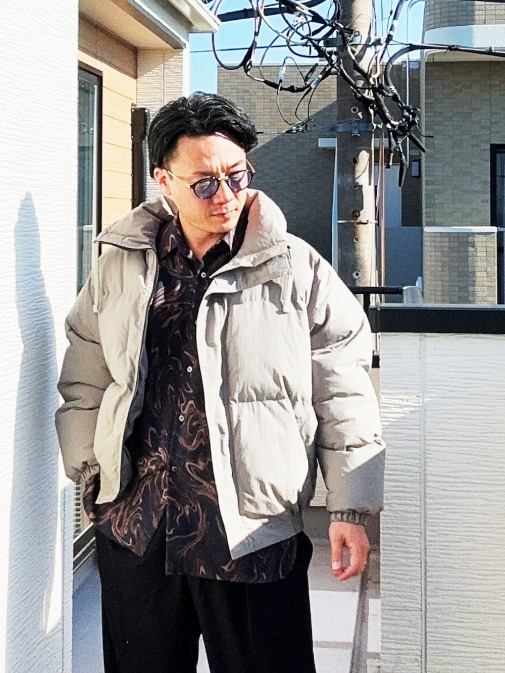 ブルー系のシャツ/ブラウス、グレー系のダウンジャケット/コート、ブラック系のスラックスを着用したメンズの冬コーディネートの5枚目の写真