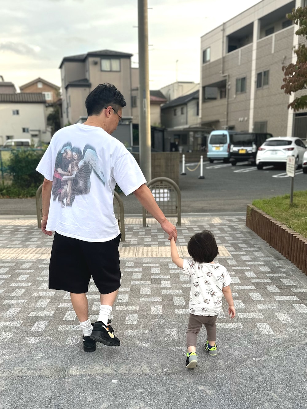 ブラック系のスニーカー、ホワイト系のTシャツ/カットソー、ブラック系のスウェットパンツを着用したメンズの秋コーディネートの2枚目の写真