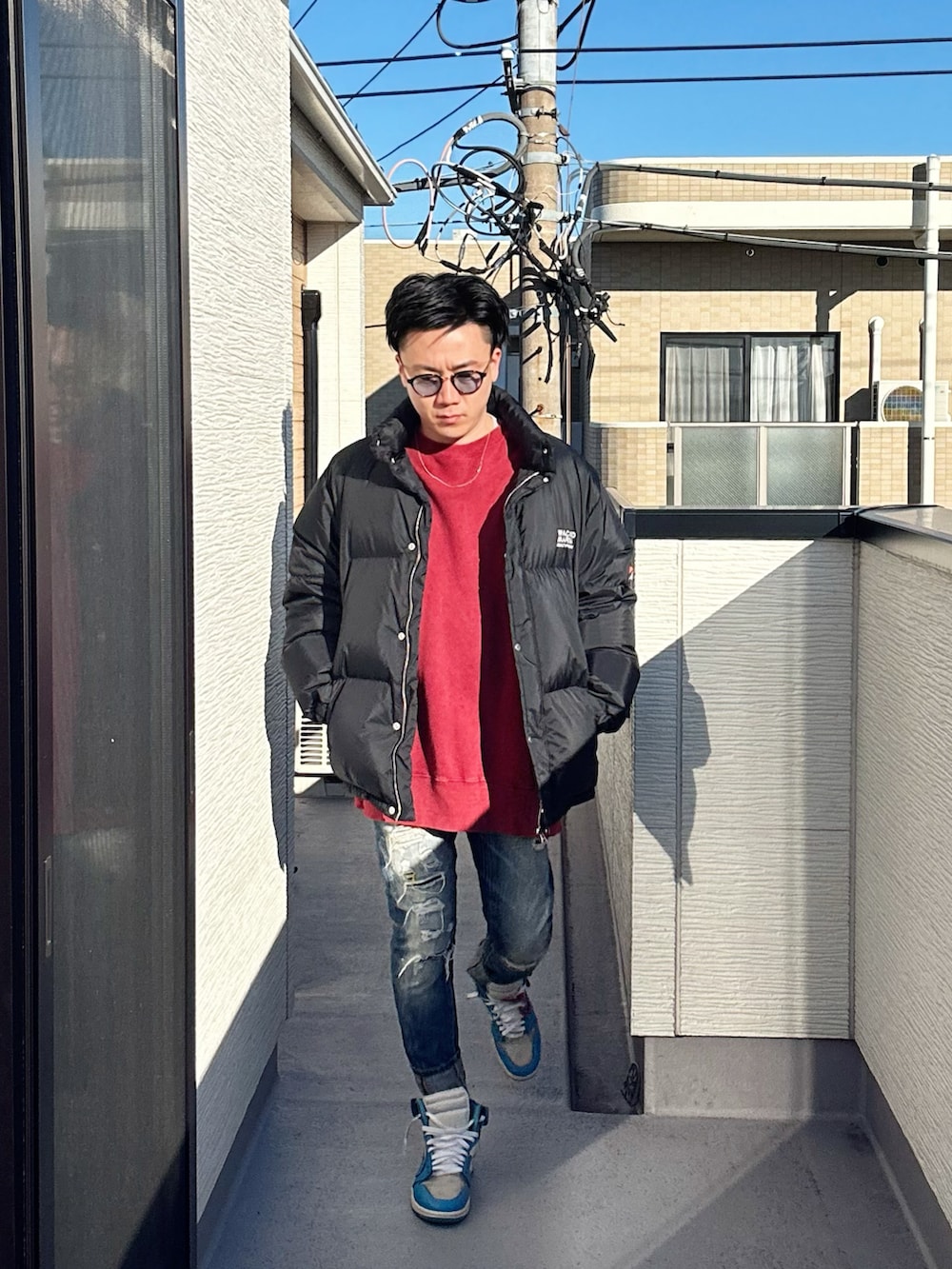 レッド系のスウェット、ブラック系のその他アウター、ブルー系のデニムパンツを着用したメンズの冬コーディネートの4枚目の写真