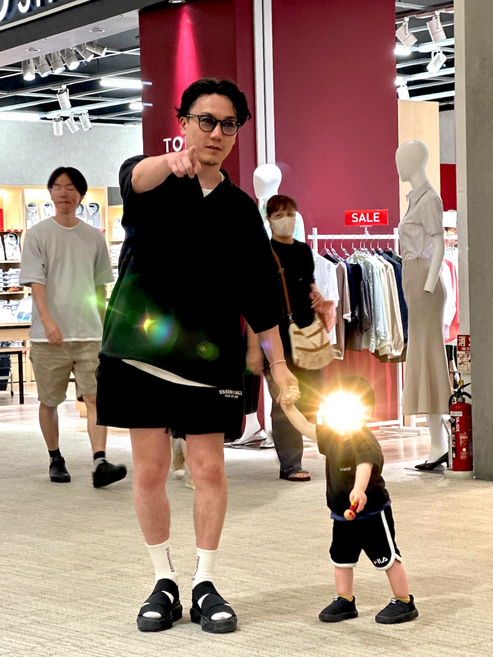 ブラック系のポロシャツ、ブラック系のスウェットパンツ、ブラック系のサンダルを着用したメンズの夏コーディネートの4枚目の写真