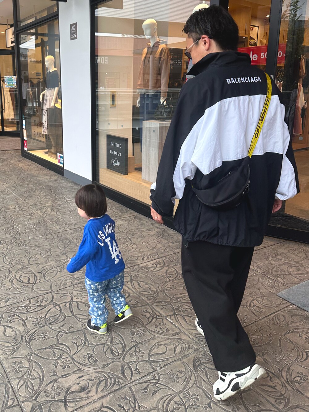 ブラック系のスウェットパンツ、ブラック系のショルダーバッグ、ブラック系のスニーカーを着用したメンズの秋コーディネートの4枚目の写真