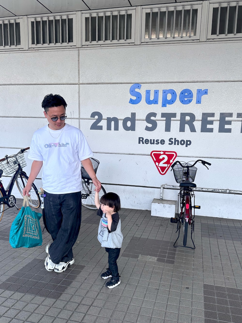 ブラック系のデニムパンツ、ブラック系のスニーカー、ホワイト系のTシャツ/カットソーを着用したメンズの秋コーディネートの2枚目の写真