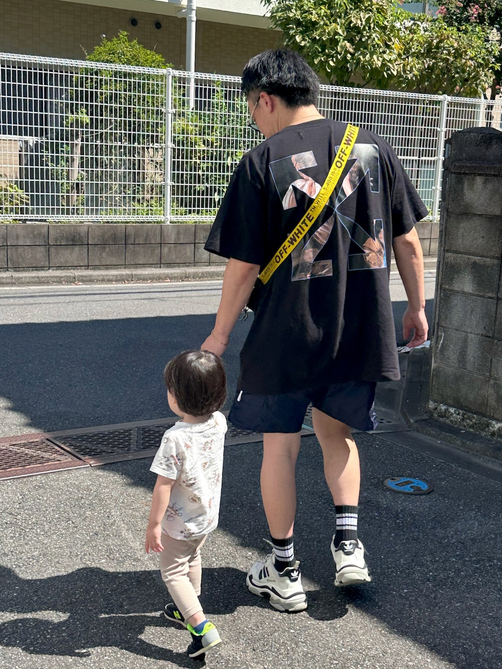 ブラック系のショルダーバッグ、ブラック系のスニーカー、ブラック系のTシャツ/カットソーを着用したメンズの秋コーディネートの3枚目の写真