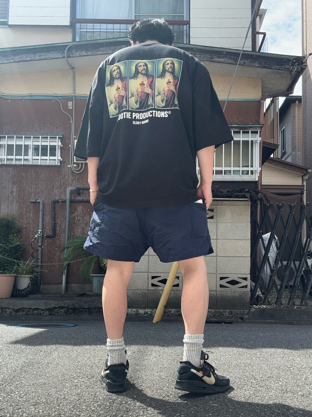 ブラック系のTシャツ/カットソー、ブルー系のパンツ、ブラック系のスニーカーを着用したメンズの夏コーディネートの4枚目の写真