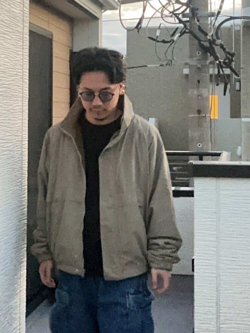 ブラック系のTシャツ/カットソー、ベージュ系のブルゾン、ブルー系のカーゴパンツを着用したメンズの秋コーディネートの3枚目の写真