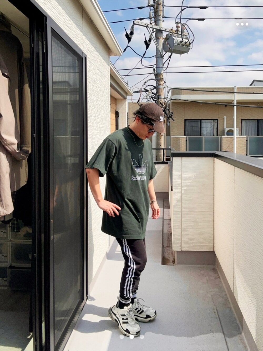 ブラック系のスウェットパンツ、グリーン系のTシャツ/カットソー、ホワイト系のシューズを着用したメンズの秋コーディネートの2枚目の写真