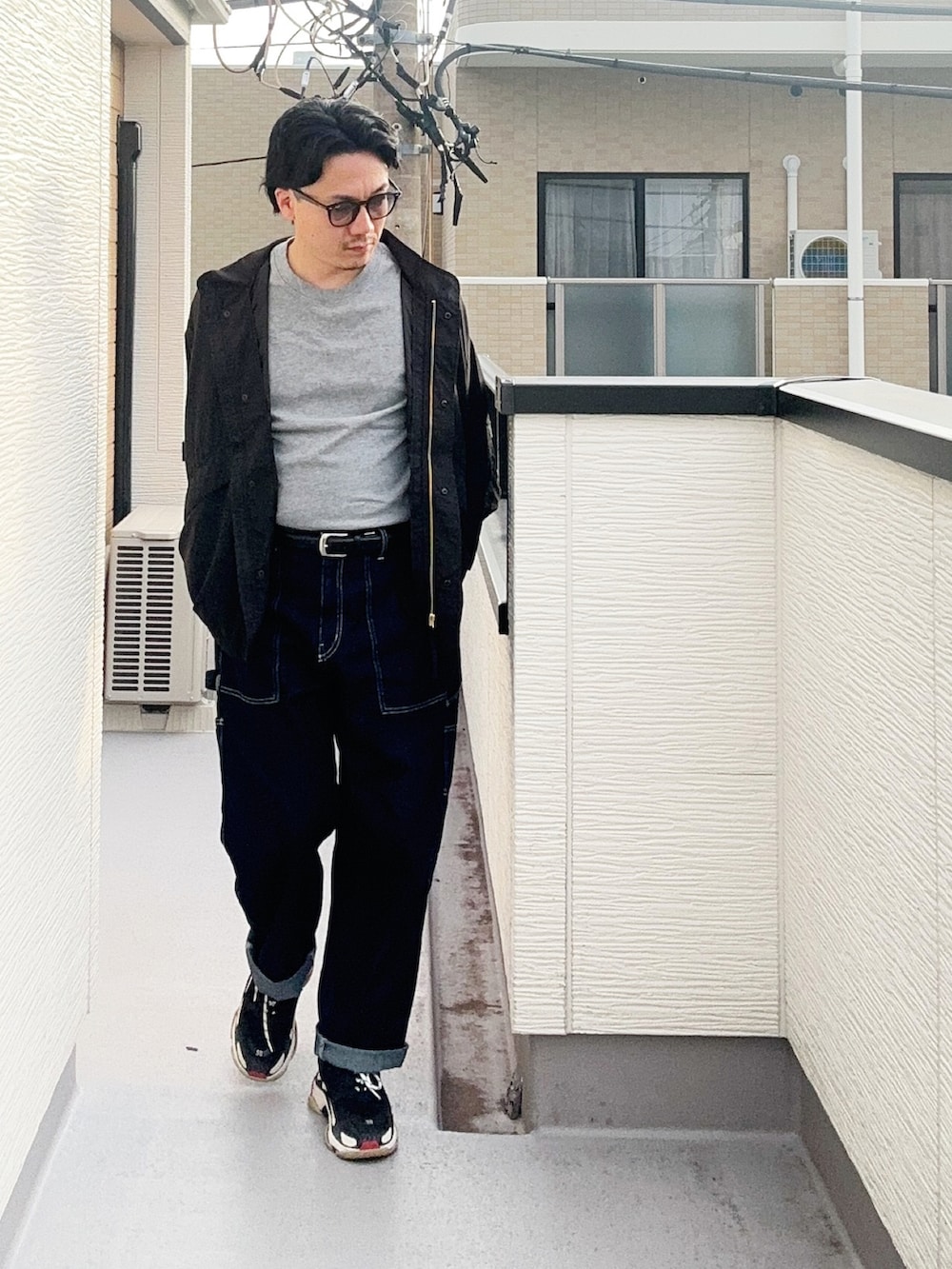 グレー系のTシャツ/カットソー、ブラック系のブルゾン、ブルー系のデニムパンツを着用したメンズの秋コーディネートの2枚目の写真