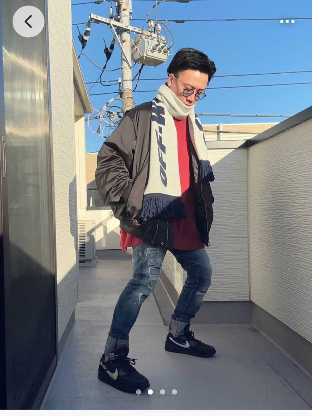 レッド系のスウェット、ブラック系のMA-1、ブルー系のデニムパンツを着用したメンズの冬コーディネートの2枚目の写真