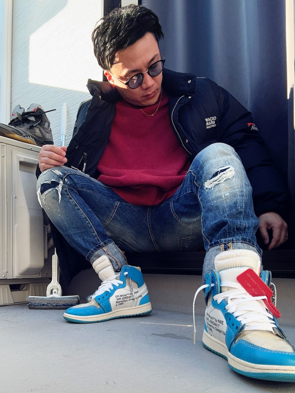 レッド系のスウェット、ブラック系のその他アウター、ブルー系のデニムパンツを着用したメンズの冬コーディネートの2枚目の写真