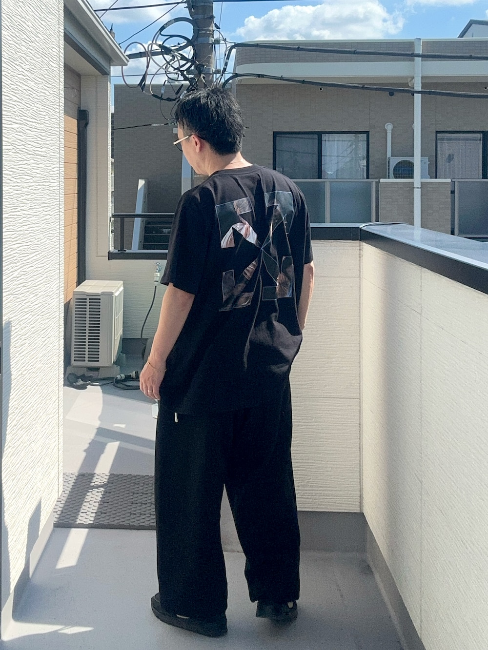 ブラック系のスウェットパンツ、ブラック系のTシャツ/カットソー、ブラック系のスニーカーを着用したメンズの秋コーディネートの2枚目の写真