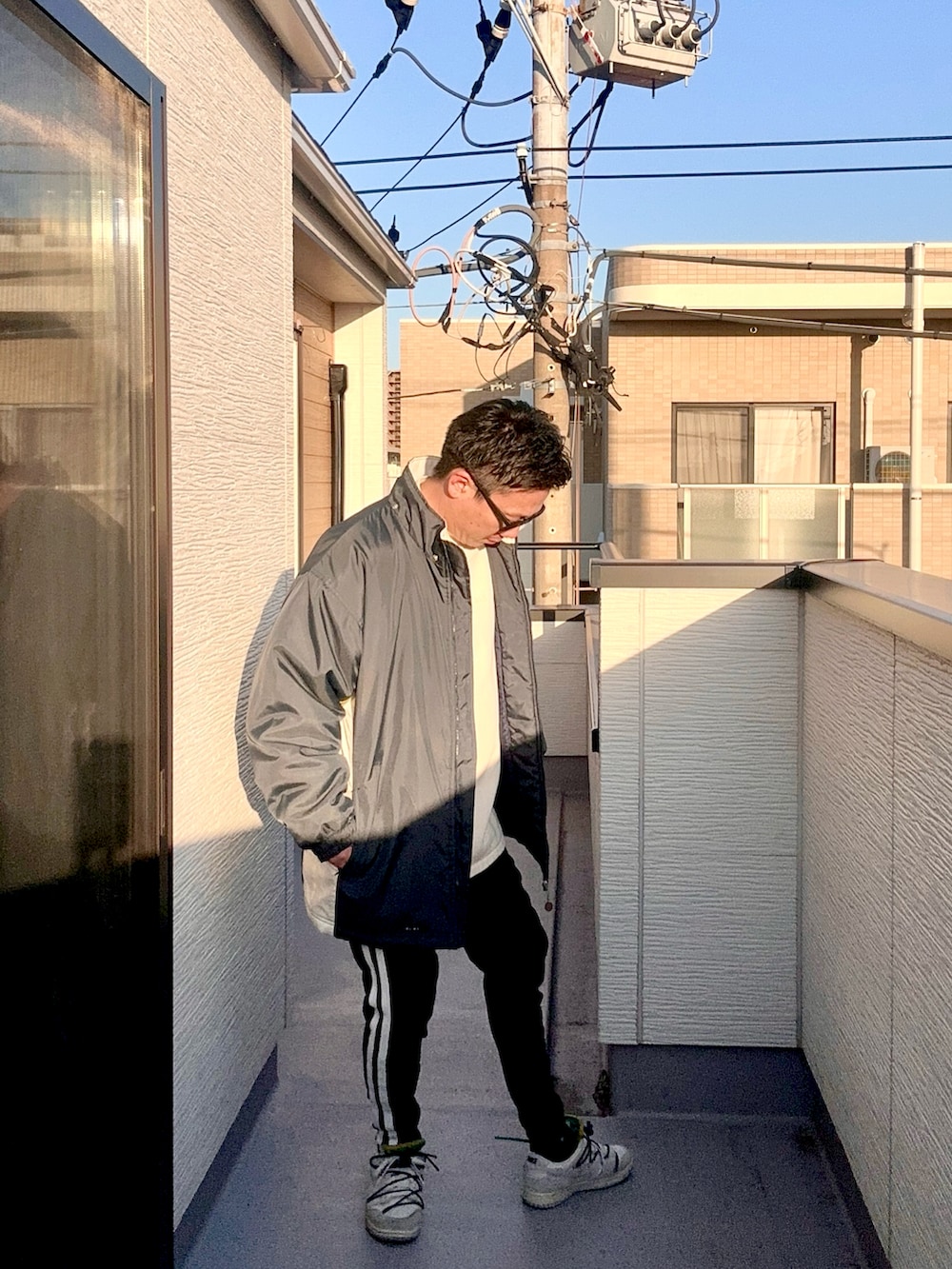 ベージュ系のスウェット、ブルー系のジャケット/アウター、ブラック系のパンツを着用したメンズの冬コーディネートの4枚目の写真