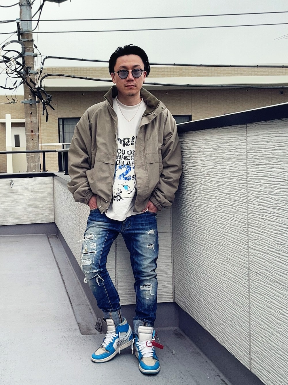 ベージュ系のブルゾン、ブルー系のデニムパンツ、ホワイト系のTシャツ/カットソーを着用したメンズの冬コーディネートの2枚目の写真