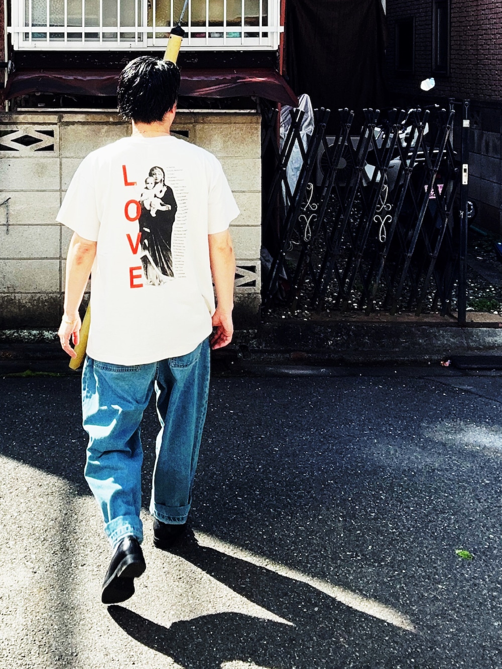 ブラック系のローファー、ホワイト系のTシャツ/カットソー、ブルー系のデニムパンツを着用したメンズの春コーディネートの2枚目の写真