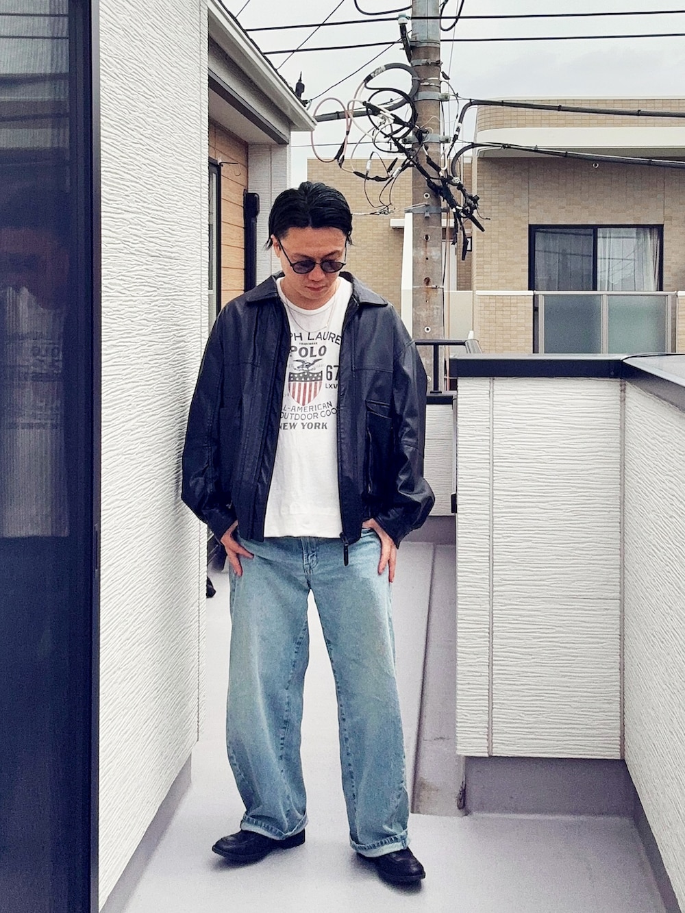 ブラック系のブルゾン、ブラック系のローファー、ホワイト系のTシャツ/カットソーを着用したメンズの春コーディネートの2枚目の写真