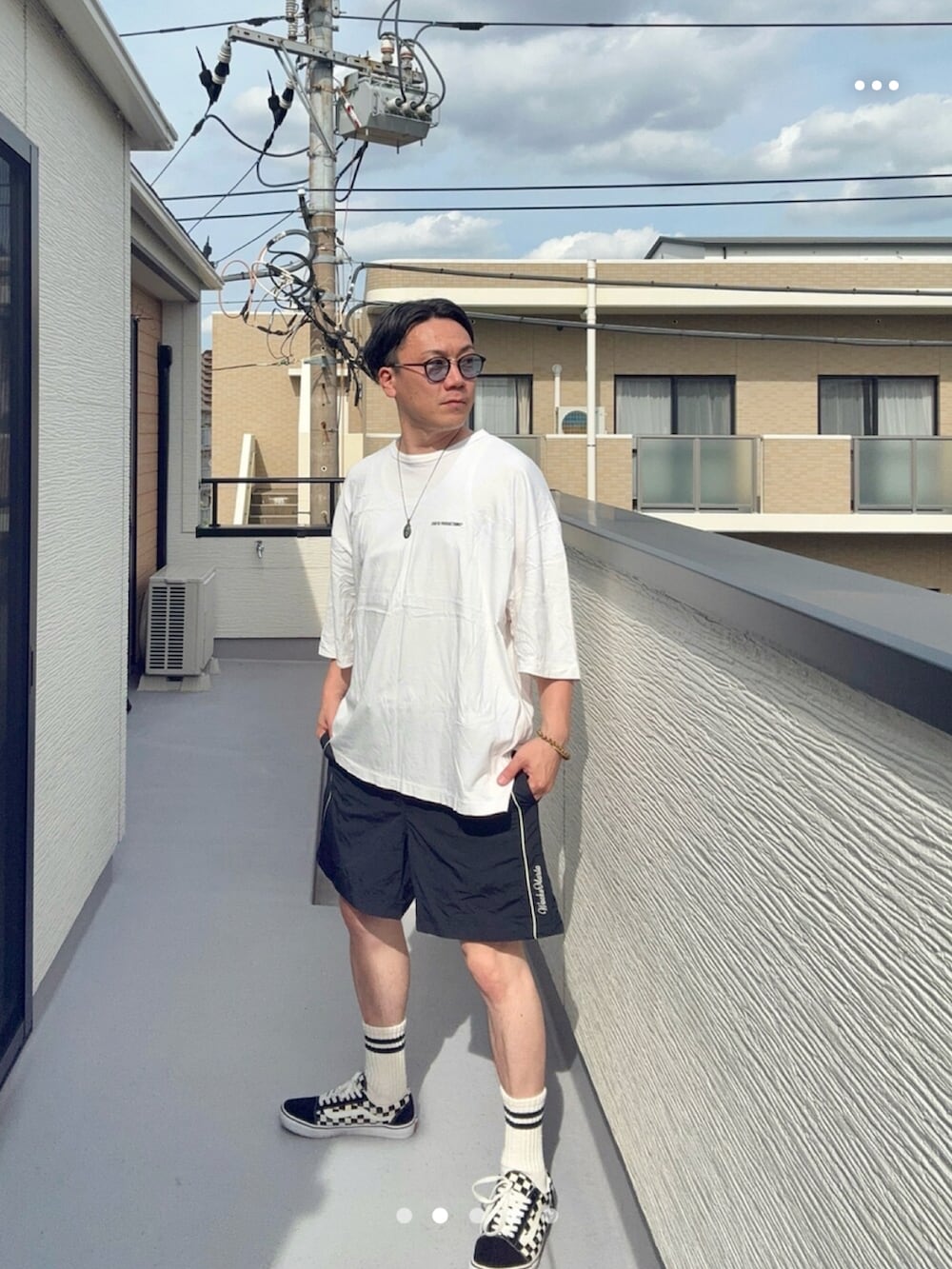 ブラック系のスニーカー、ホワイト系のTシャツ/カットソー、ブラック系のパンツを着用したメンズの夏コーディネートの2枚目の写真