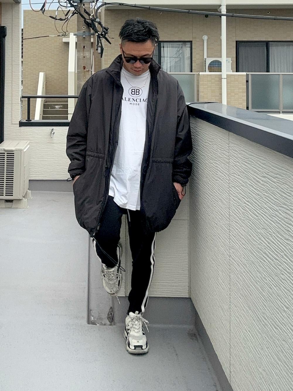 ブラック系のその他アウター、ホワイト系のTシャツ/カットソー、ブラック系のパンツを着用したメンズの秋コーディネートの5枚目の写真