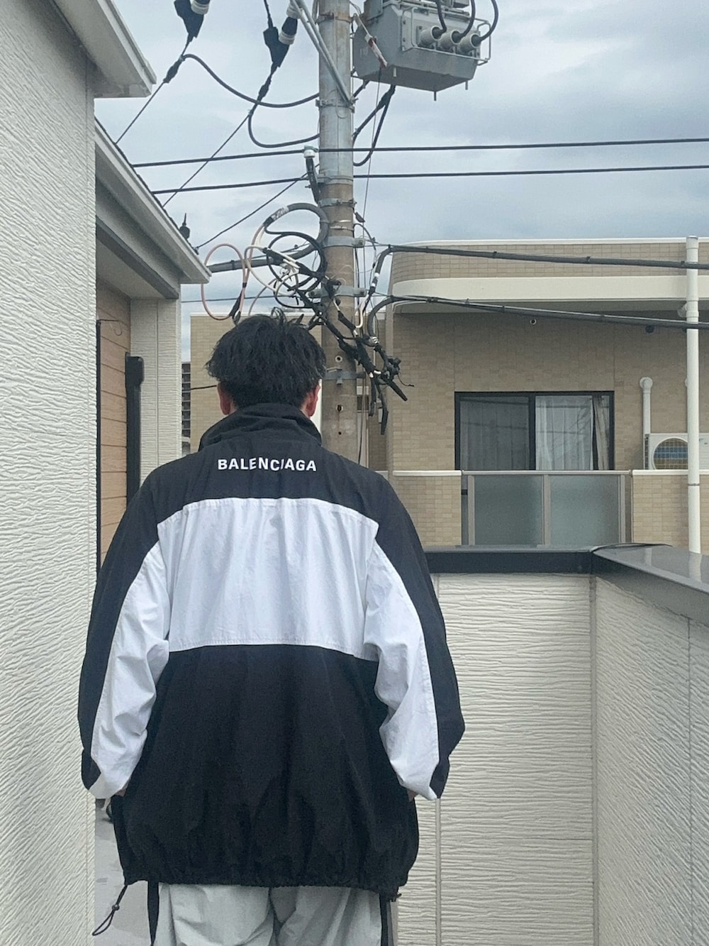 グレー系のその他パンツ、ブラック系のTシャツ/カットソー、ブラック系のナイロンジャケットを着用したメンズの秋コーディネートの5枚目の写真
