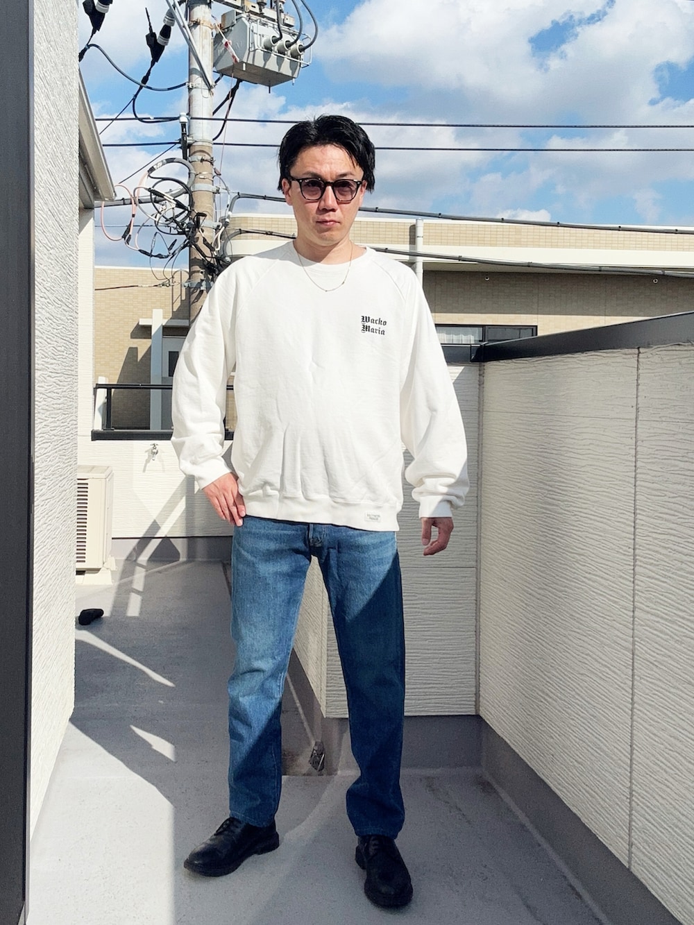 ブルー系のデニムパンツ、ホワイト系のスウェット、ブラック系のドレスシューズを着用したメンズの冬コーディネートの2枚目の写真