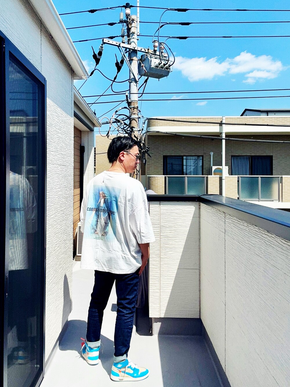 ホワイト系のTシャツ/カットソー、ブルー系のデニムパンツ、ブルー系のスニーカーを着用したメンズの春コーディネートの5枚目の写真