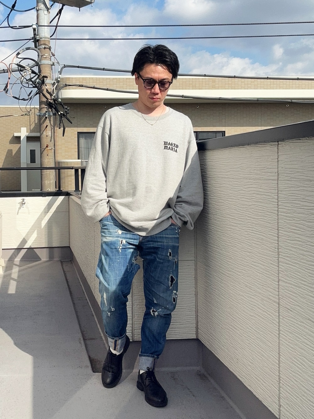 ブルー系のデニムパンツ、グレー系のスウェット、ブラック系のドレスシューズを着用したメンズの冬コーディネートの3枚目の写真