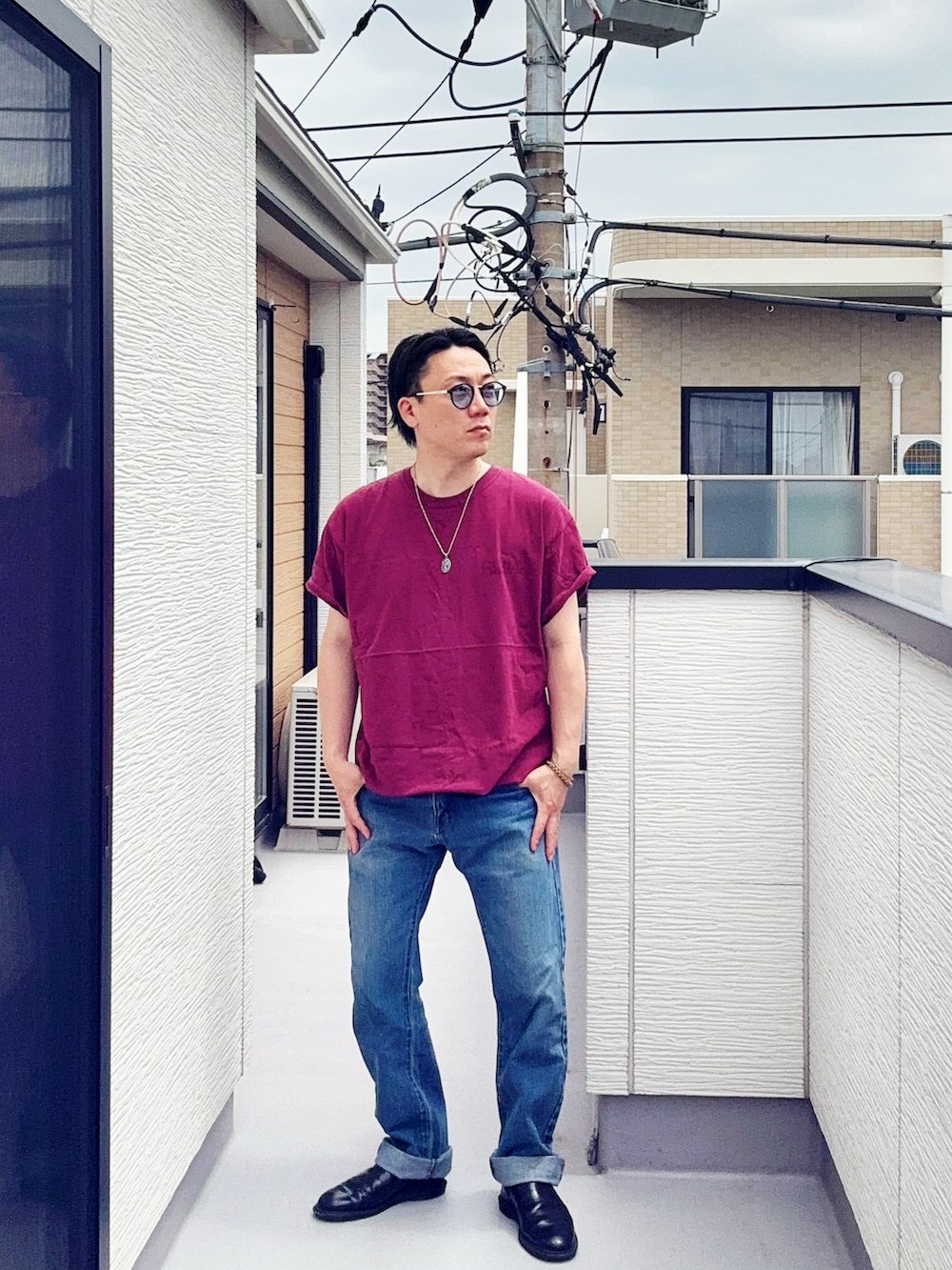 ブルー系のデニムパンツ、レッド系のTシャツ/カットソー、ブラック系のブーツを着用したメンズの春コーディネートの2枚目の写真