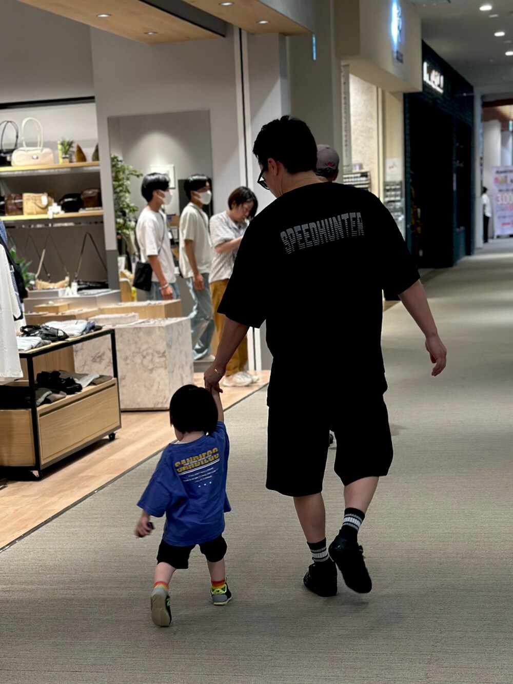 ブラック系のスニーカー、ブラック系のTシャツ/カットソー、ブラック系のスウェットパンツを着用したメンズの夏コーディネートの3枚目の写真