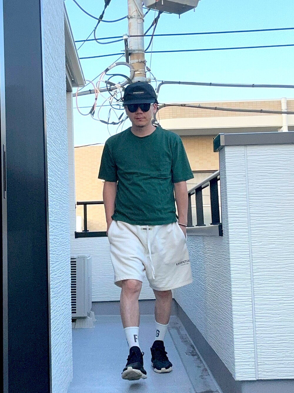 グリーン系のTシャツ/カットソー、ホワイト系のスウェットパンツ、ブラック系のスニーカーを着用したメンズの夏コーディネートの3枚目の写真