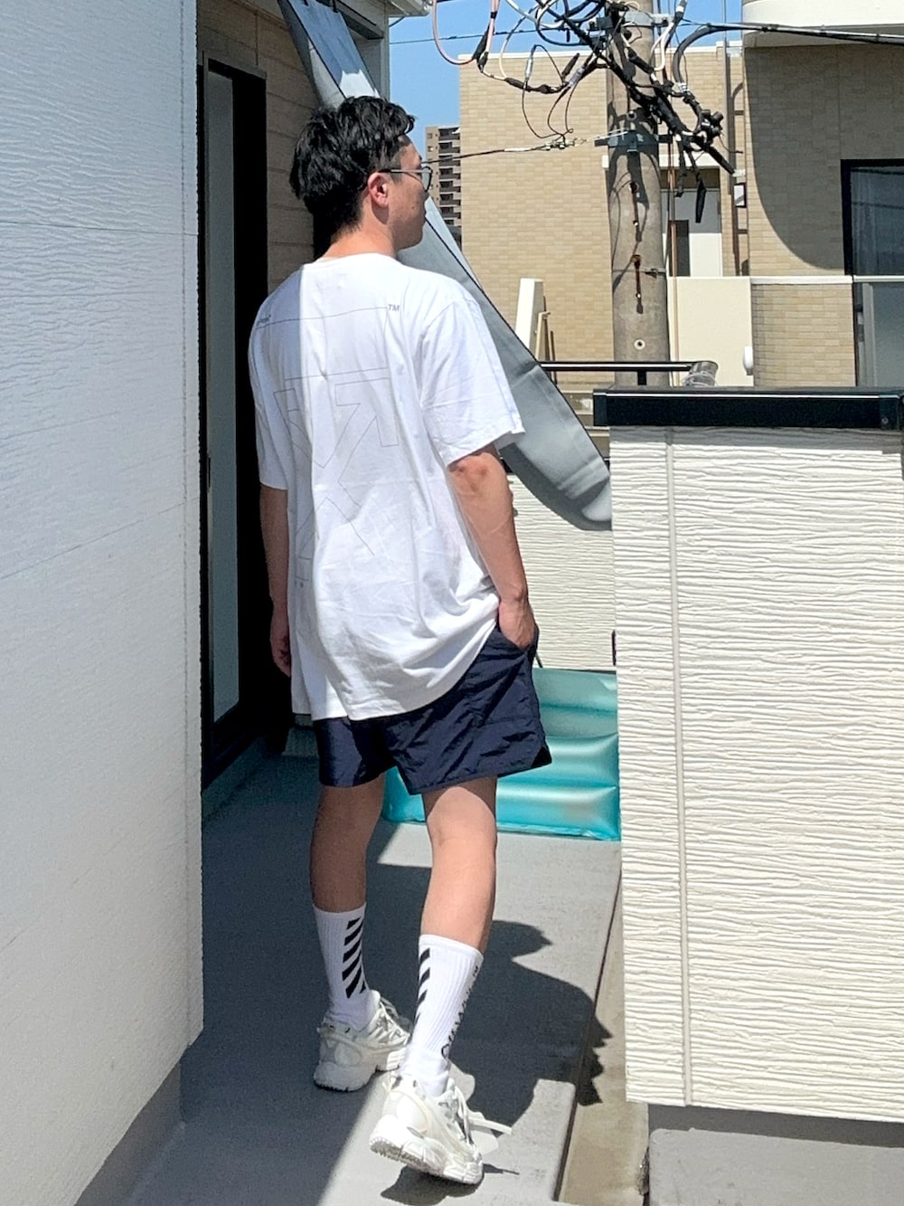 ホワイト系のトップス、ブルー系のパンツ、ホワイト系のスニーカーを着用したメンズの夏コーディネートの4枚目の写真