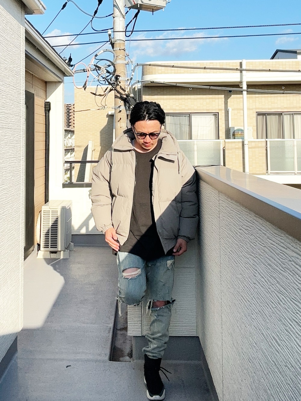 グレー系のダウンジャケット/コート、ブラック系のTシャツ/カットソー、ブルー系のデニムパンツを着用したメンズの秋コーディネートの3枚目の写真