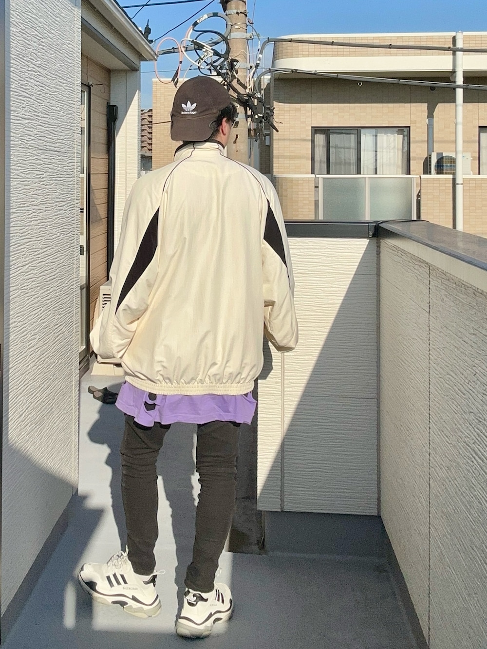 パープル系のTシャツ/カットソー、ホワイト系のナイロンジャケット、ブラック系のデニムパンツを着用したメンズの秋コーディネートの5枚目の写真