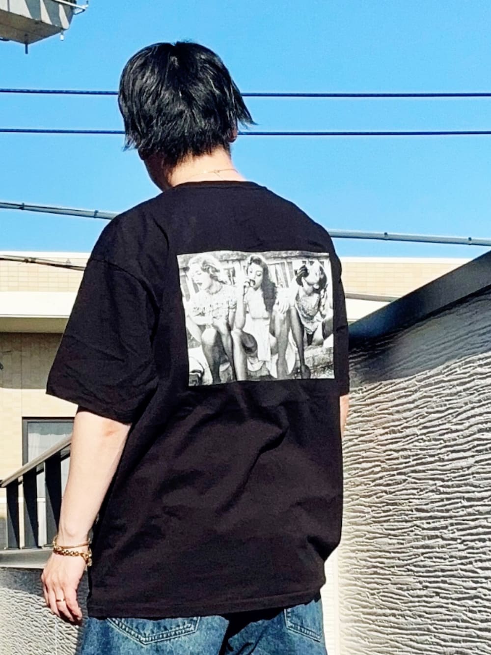 ブラック系のTシャツ/カットソー、ブルー系のデニムパンツ、ブラック系のブーツを着用したメンズの春コーディネートの4枚目の写真