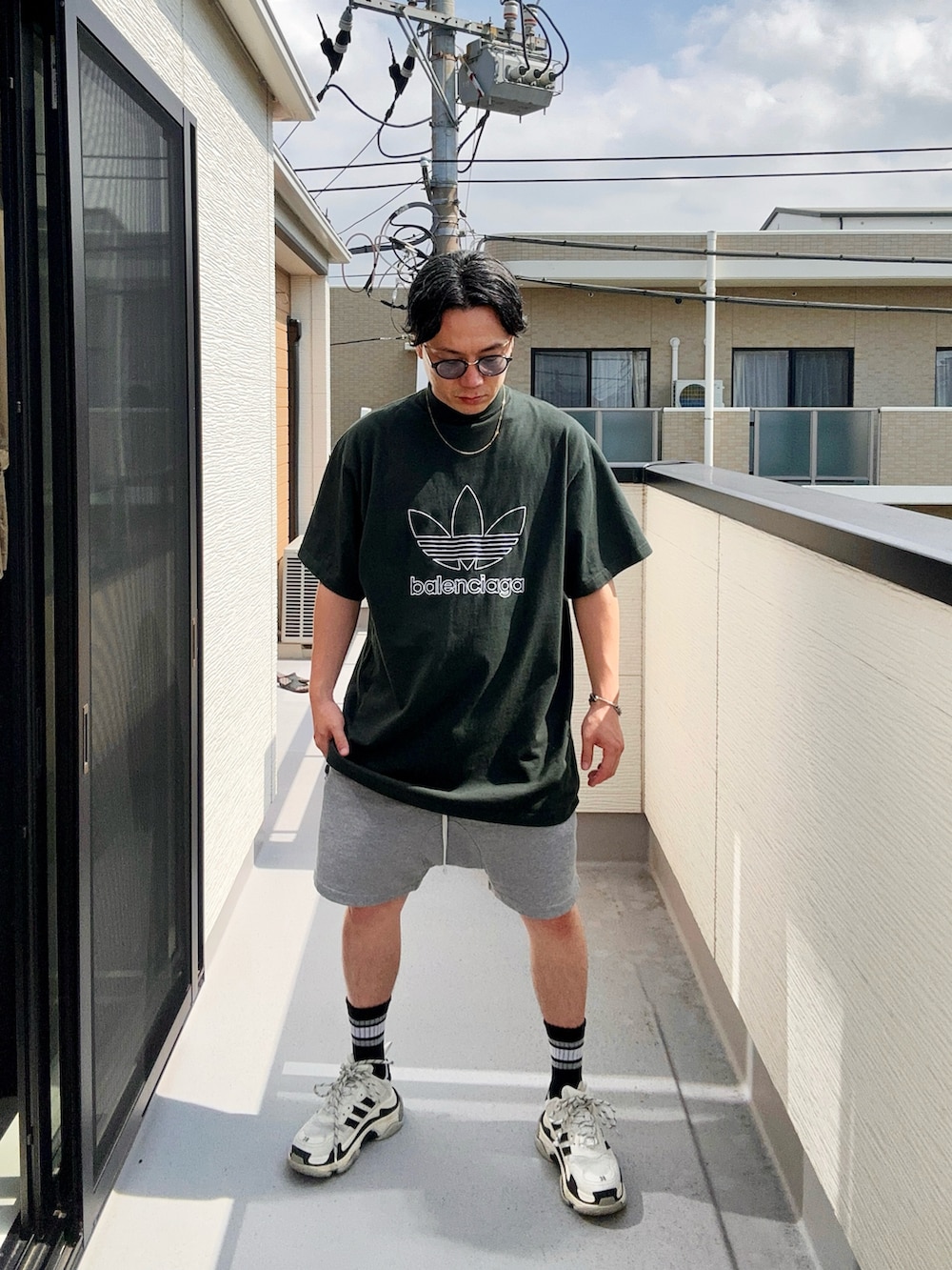 グリーン系のTシャツ/カットソー、グレー系のパンツ、ホワイト系のシューズを着用したメンズの秋コーディネートの4枚目の写真