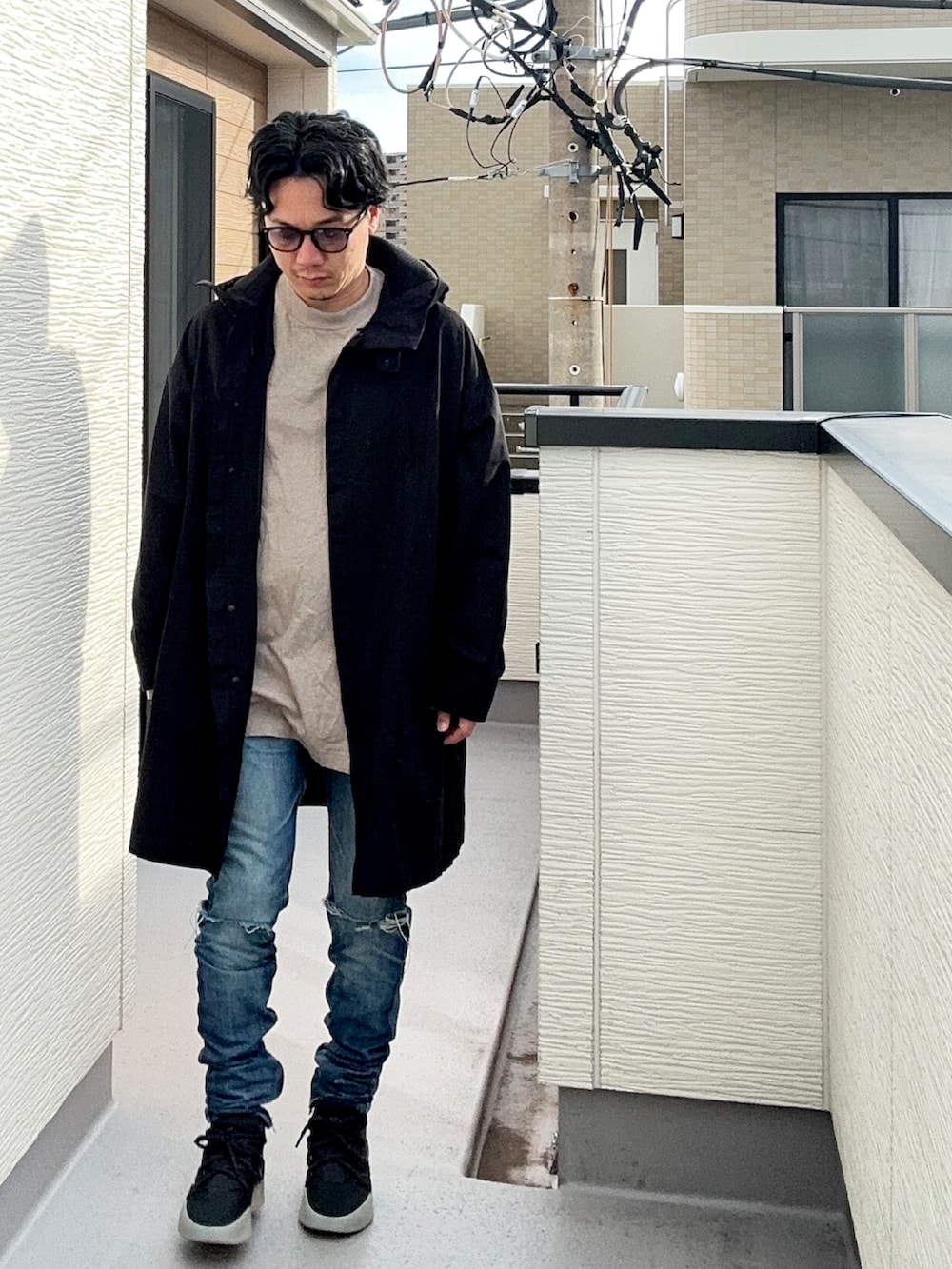 ブラック系のスニーカー、ブルー系のデニムパンツ、グレー系のTシャツ/カットソーを着用したメンズの秋コーディネートの2枚目の写真