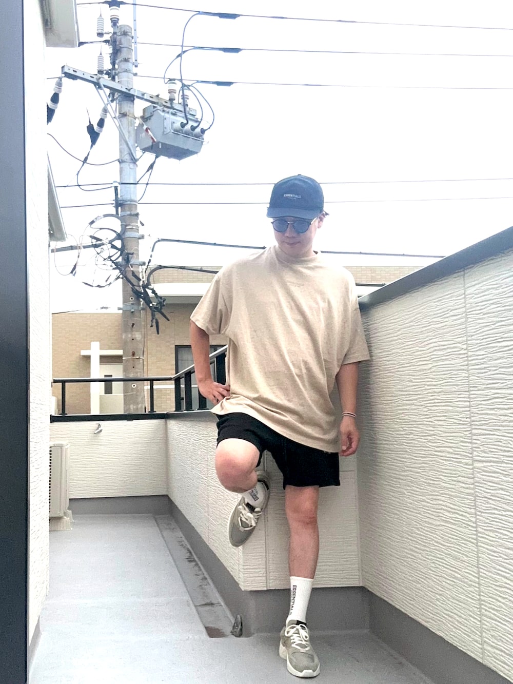 ベージュ系のTシャツ/カットソー、ブラック系のスウェットパンツ、グレー系のスニーカーを着用したメンズの夏コーディネートの2枚目の写真