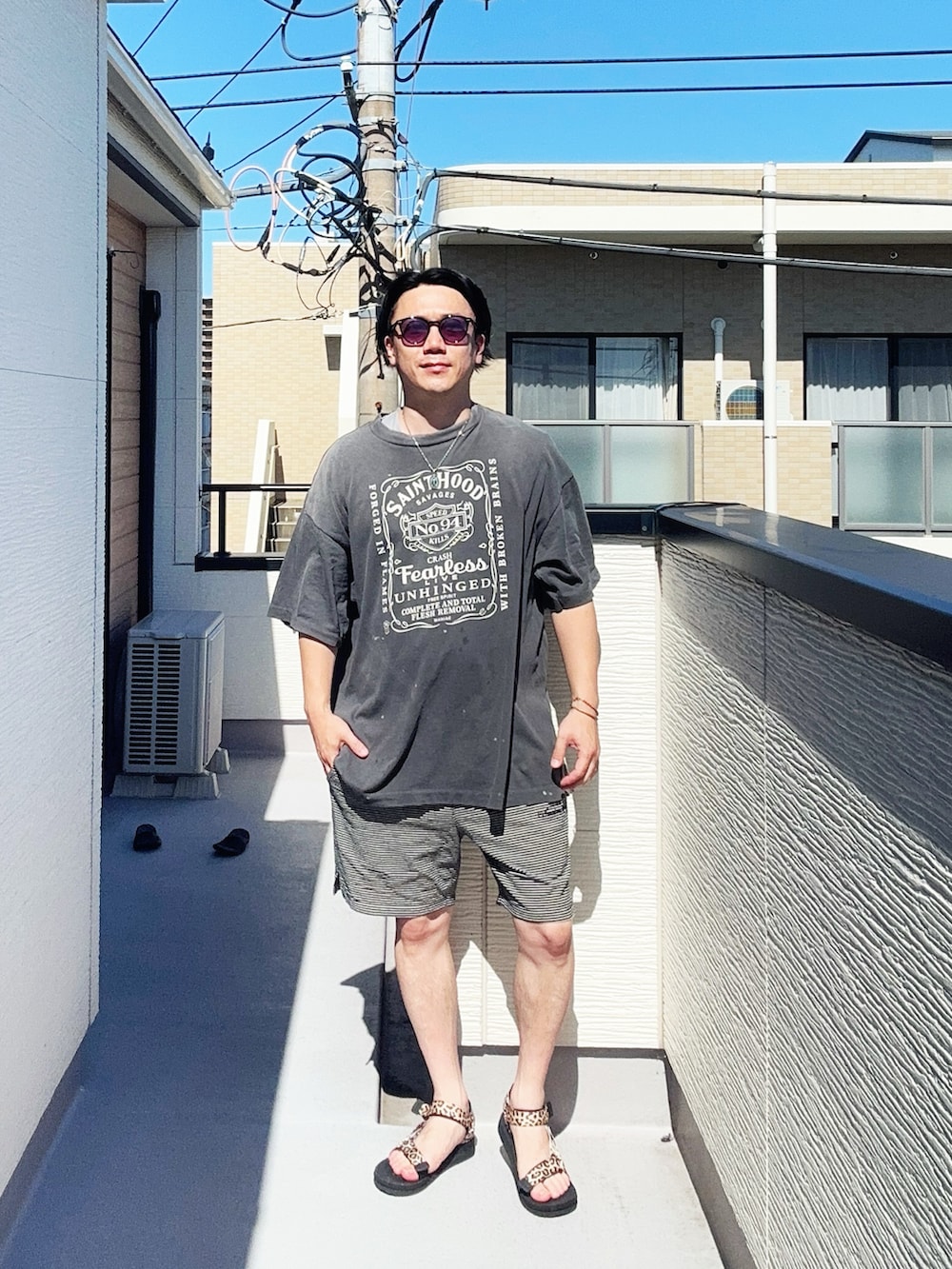 ブラック系のTシャツ/カットソー、ブラック系のパンツ、その他のサンダルを着用したメンズの夏コーディネートの4枚目の写真