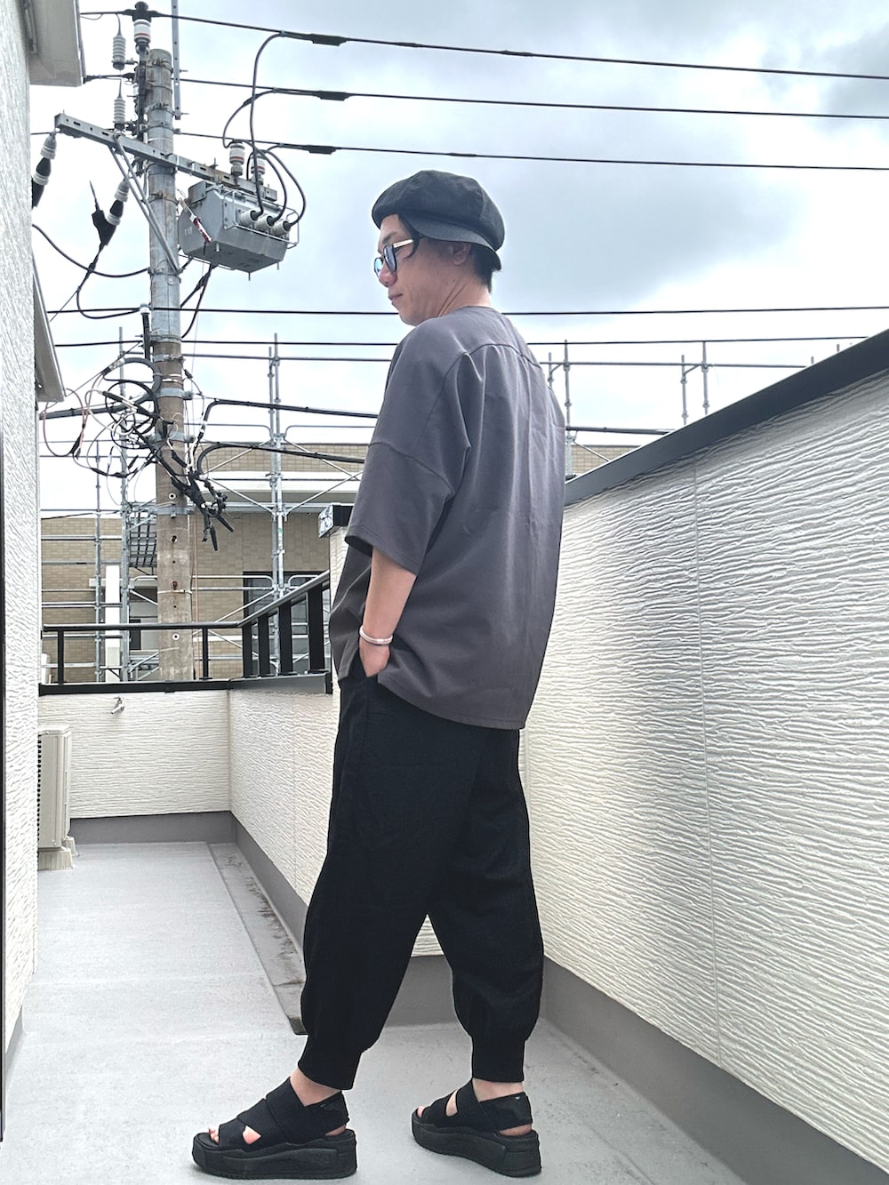 グレー系のTシャツ/カットソー、ブラック系のその他パンツ、ブラック系のサンダルを着用したメンズの夏コーディネートの3枚目の写真