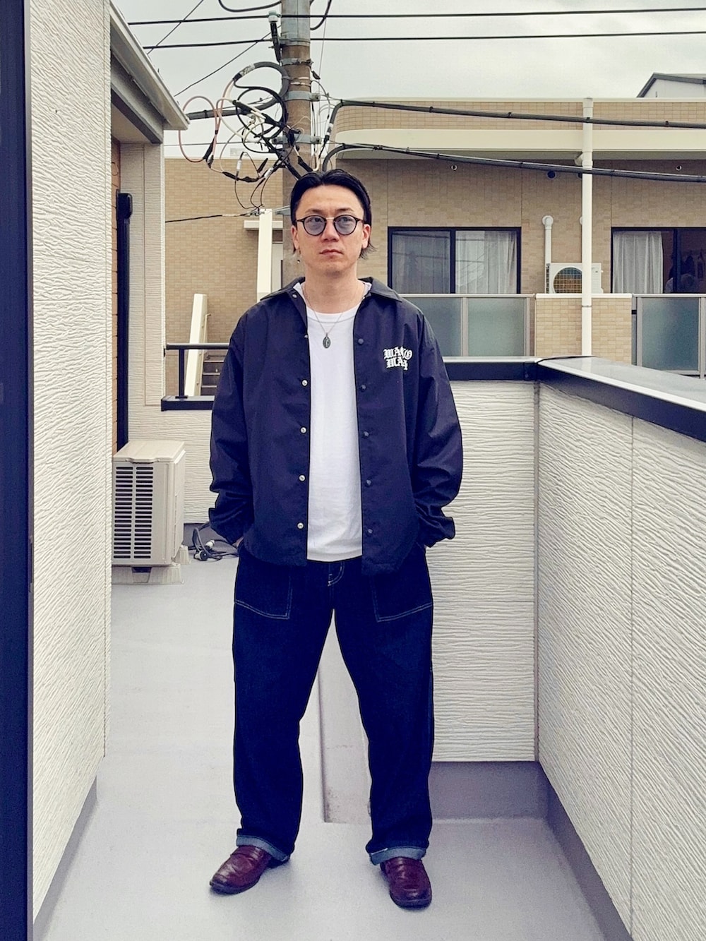 ブルー系のデニムパンツ、ホワイト系のTシャツ/カットソー、ブラック系のジャケット/アウターを着用したメンズの春コーディネートの3枚目の写真