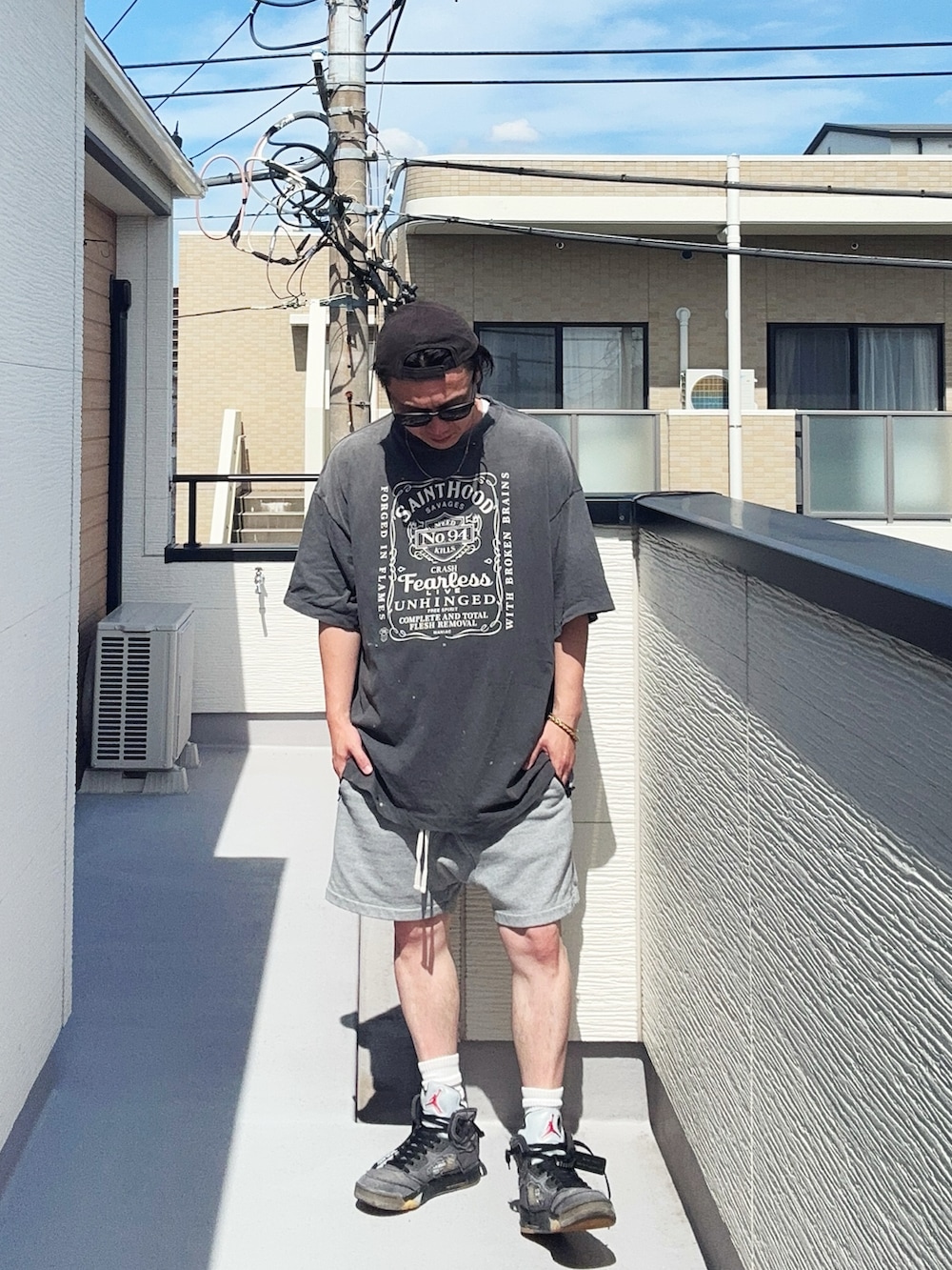 ブラック系のTシャツ/カットソー、グレー系のパンツ、グレー系のスニーカーを着用したメンズの夏コーディネートの2枚目の写真