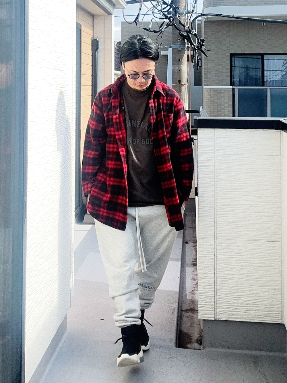 ブラック系のTシャツ/カットソー、レッド系のシャツ/ブラウス、グレー系のスウェットパンツを着用したメンズの秋コーディネートの2枚目の写真