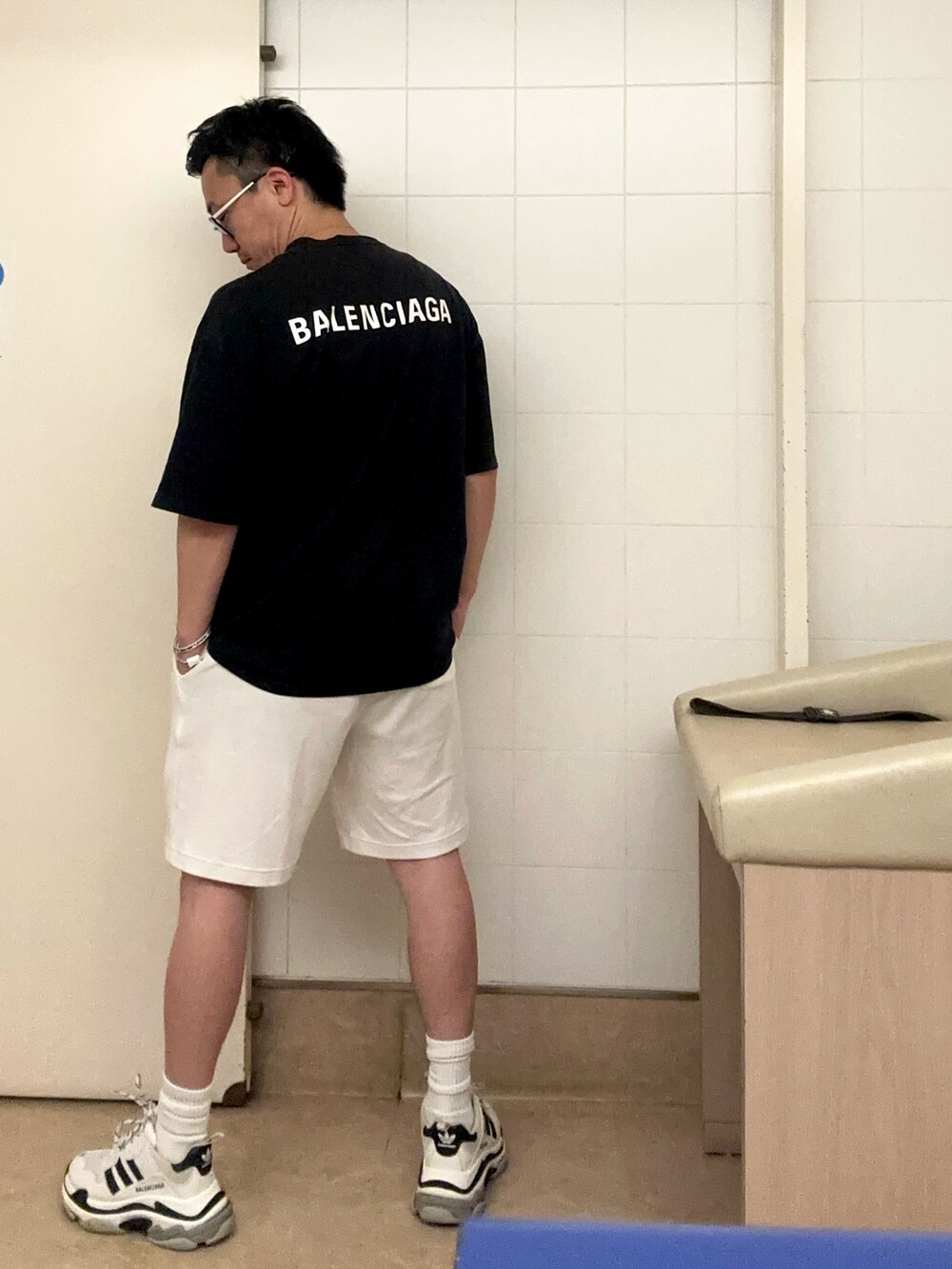 ブラック系のTシャツ/カットソー、ホワイト系のパンツ、ホワイト系のシューズを着用したメンズの秋コーディネートの2枚目の写真