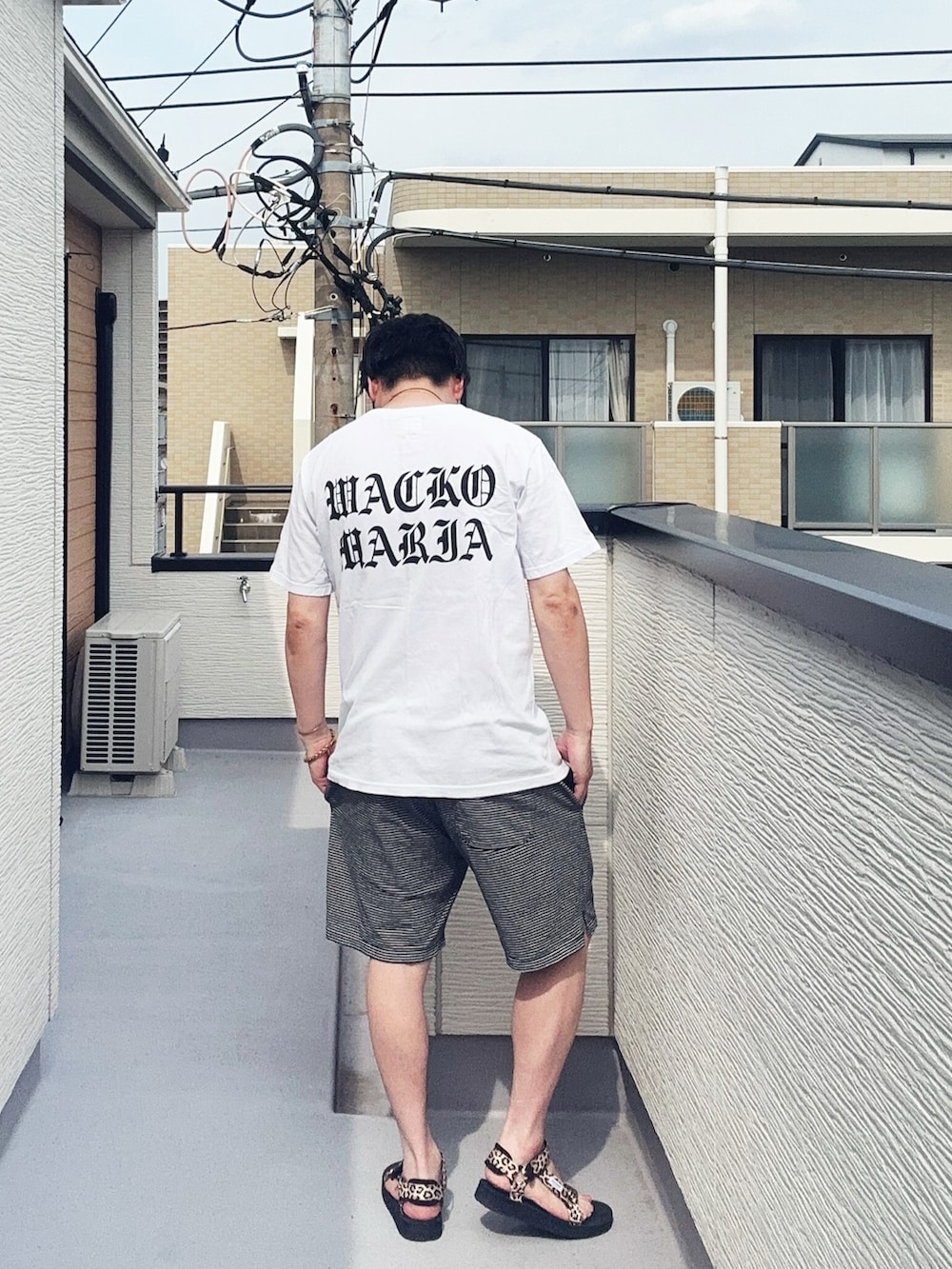 ホワイト系のTシャツ/カットソー、ブラック系のパンツ、その他のサンダルを着用したメンズの夏コーディネートの3枚目の写真