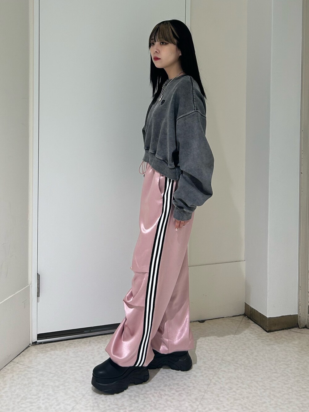 ピンク系のその他パンツ、ブラック系のスウェット、ブラック系のブーツを着用したレディースの冬コーディネートの2枚目の写真