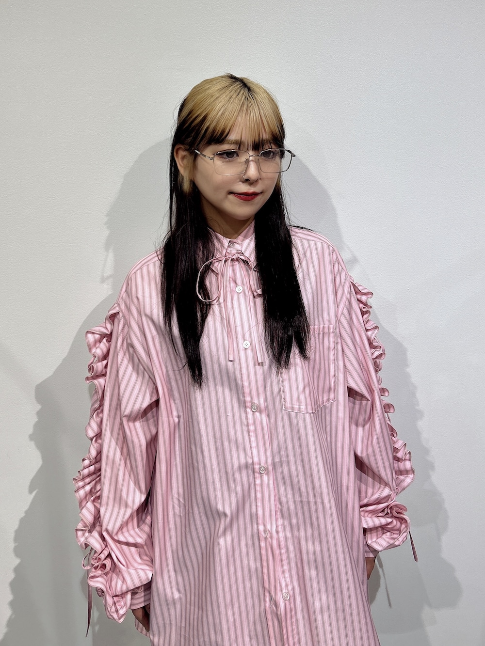 ピンク系のシャツ/ブラウス、ブラック系のブーツを着用したレディースの冬コーディネートの4枚目の写真