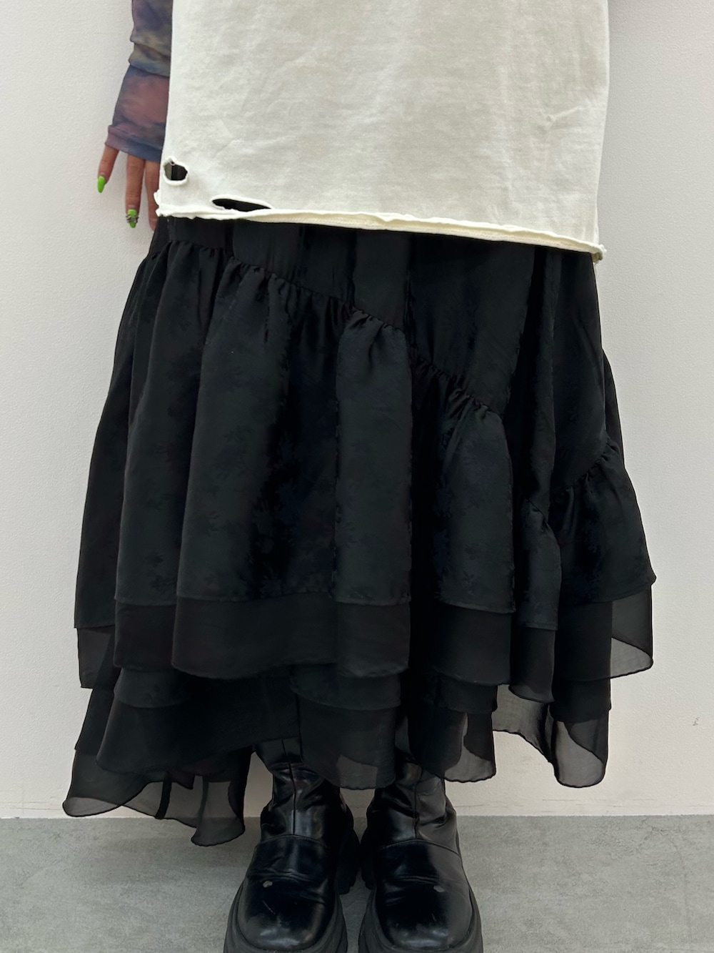 ホワイト系のTシャツ/カットソー、ブラック系のスカート、ブラック系のブーツを着用したレディースの春コーディネートの6枚目の写真