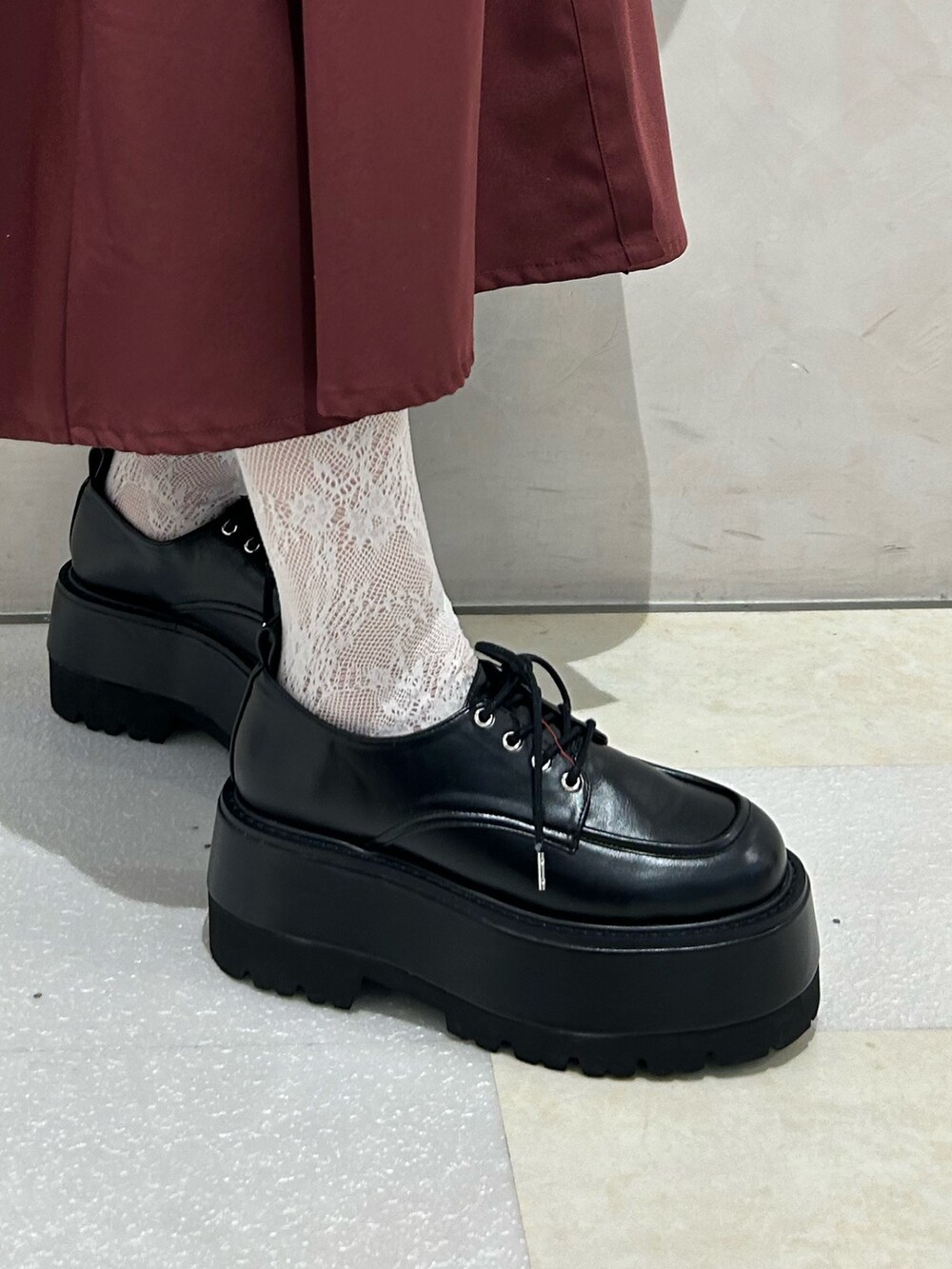 レッド系のワンピース、ブラック系のドレスシューズを着用したレディースの秋コーディネートの7枚目の写真