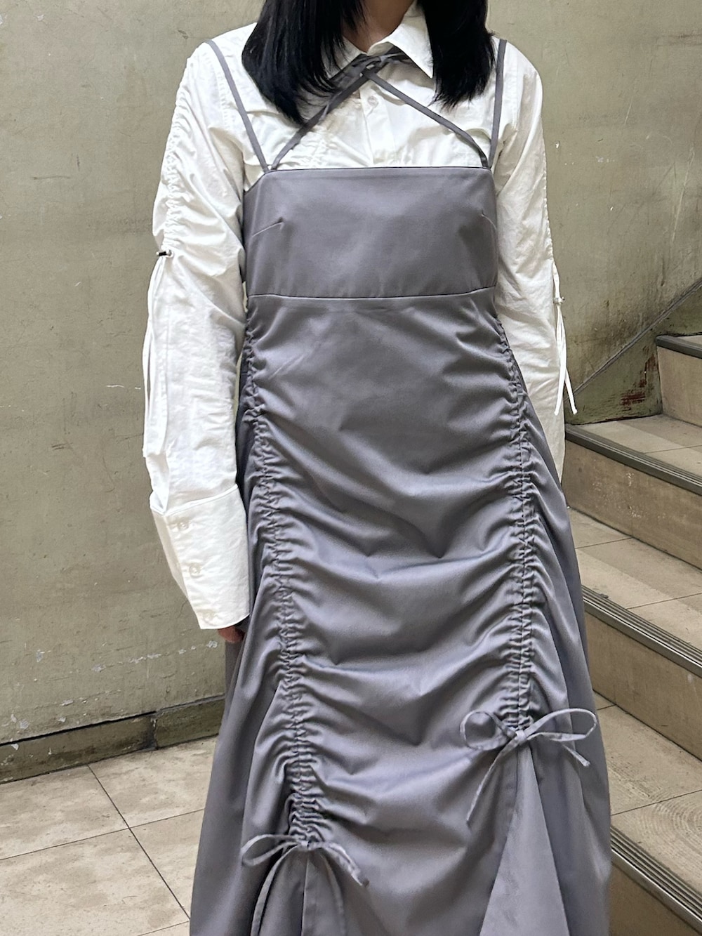 グレー系のワンピース、ホワイト系のシャツ/ブラウス、ブラック系のパンプスを着用したレディースの冬コーディネートの4枚目の写真