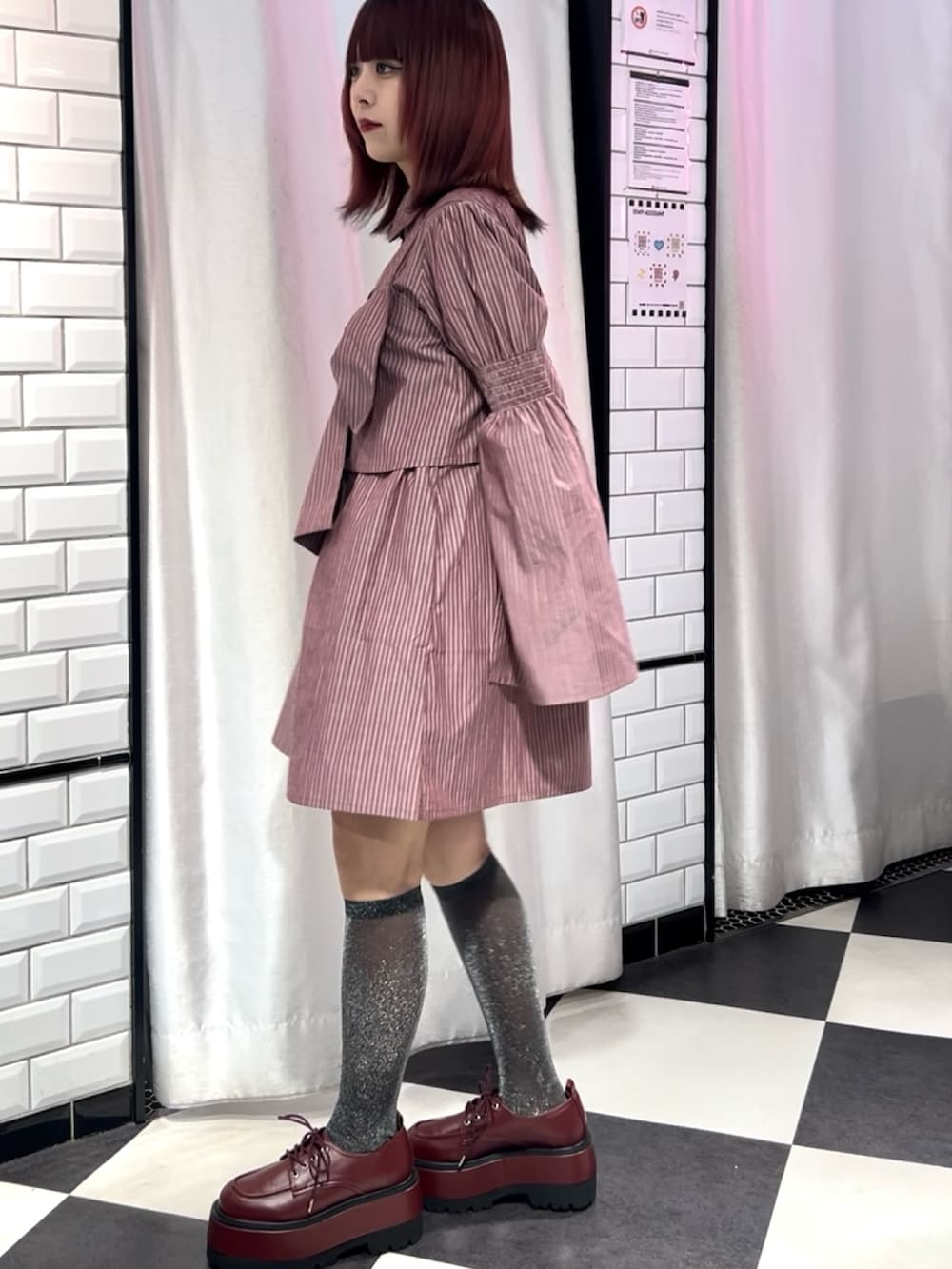 レッド系のシャツワンピース、レッド系のドレスシューズ、ゴールド系のブレスレットを着用したレディースの夏コーディネートの2枚目の写真