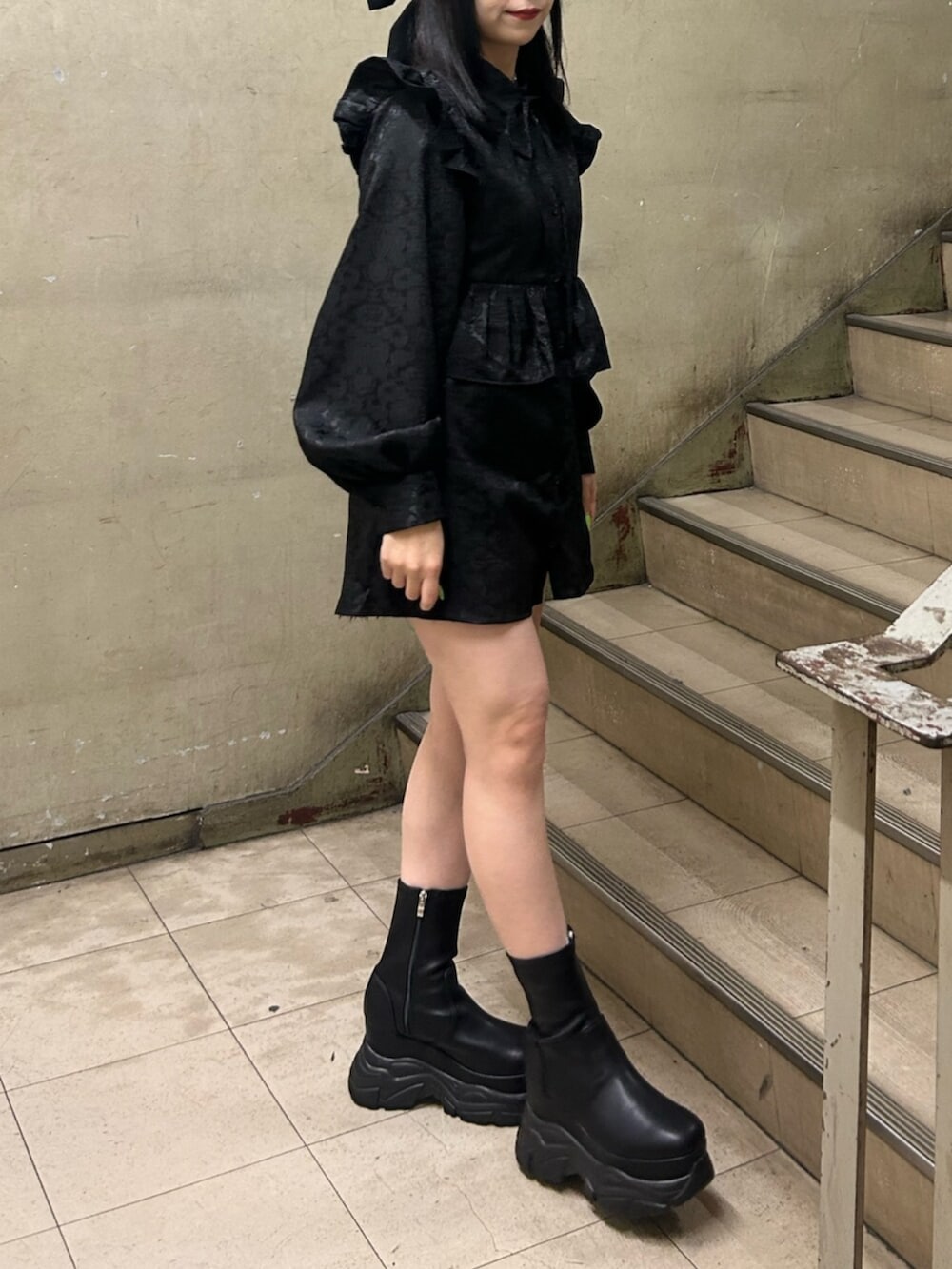 ブラック系のブーツ、ブラック系のシャツ/ブラウス、ブラック系のバレッタ/ヘアクリップを着用したレディースの冬コーディネートの2枚目の写真